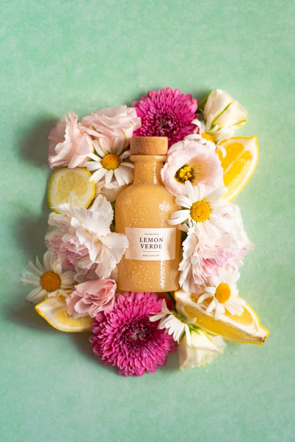 butelka z h&m otoczona kwiatami. fotografia produktowa