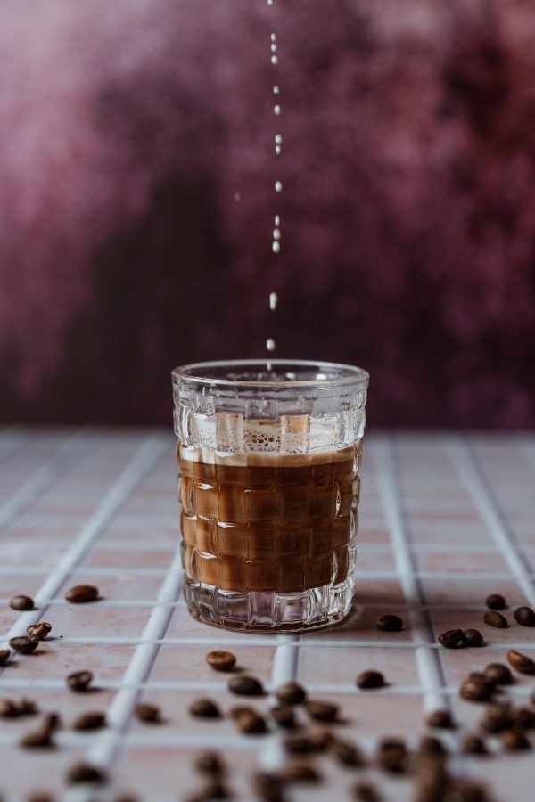 szklanka z kawą na kafelkowym blacie na fioletowym tle
