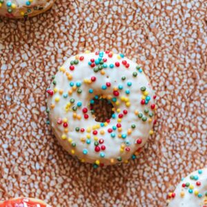 kolorowe donuty z posypką na pomarańczowym tle