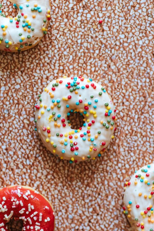 kolorowe donuty z posypką na pomarańczowym tle