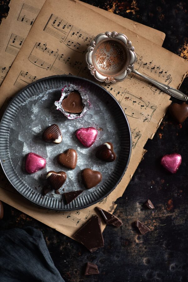 czekoladki serca na blaszanym talerzu i ciemnym tle.