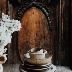 Tło fotograficzne Portone — ciemne rzeźbione drzwi z ceramiką rzemieślniczą i białymi kwiatami — mbackdrops