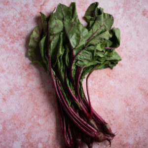 Tło fotograficzne Malva — brudny róż ze świeżymi burakami z liśćmi, flat lay kulinarny — mbackdrops