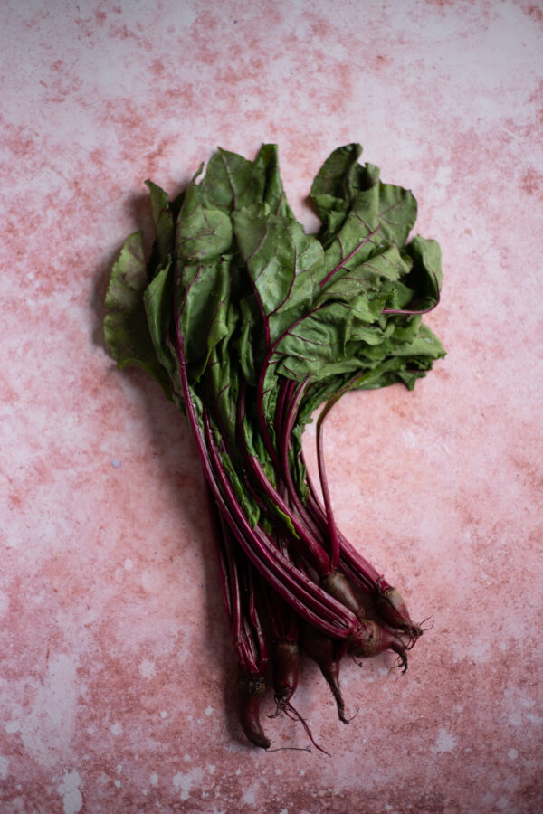 Tło fotograficzne Malva — brudny róż ze świeżymi burakami z liśćmi, flat lay kulinarny — mbackdrops