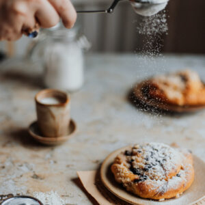 Tło fotograficzne Vecchio— przetarty tynk z drożdżówką posypaną cukrem pudrem i espresso, fotografia kulinarna — mbackdrops